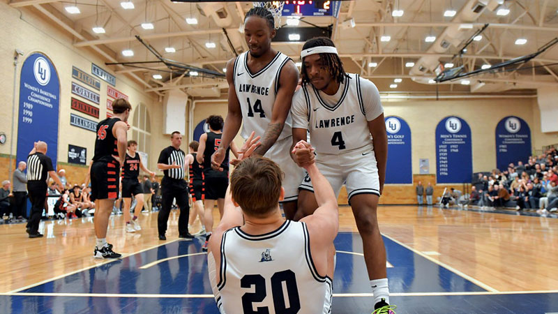 Lawrence Basketball Team helping teammate up